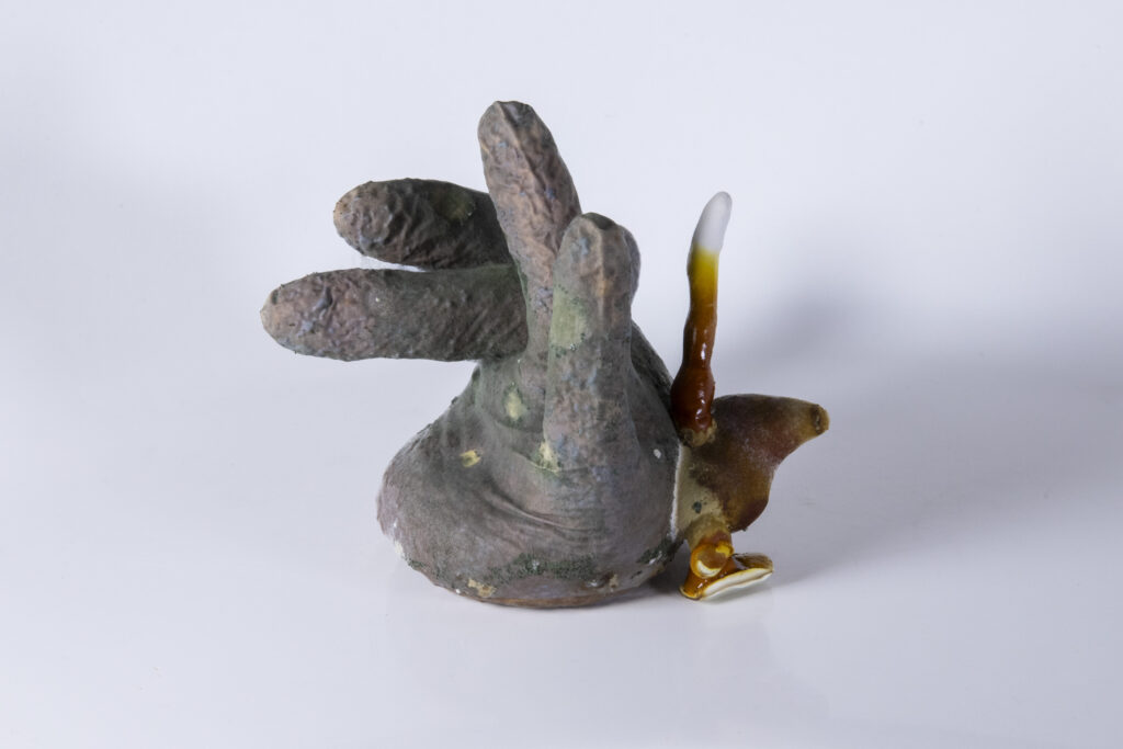 Objekt aus Latexhandschuh, durchzogen von Myzel, mit fingerartigen Ausformungen unterschiedlicher Stärke.