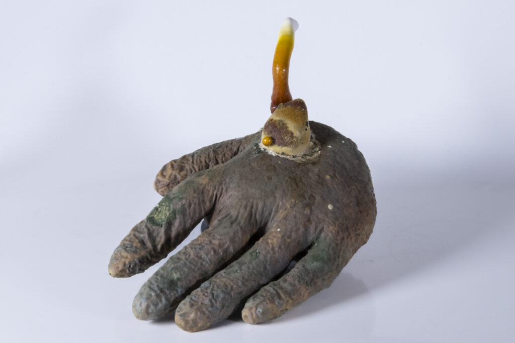 Latexhandschuh mit unregelmäßig gewachsenen myzelartigen Strukturen, verteilt über die Oberfläche.