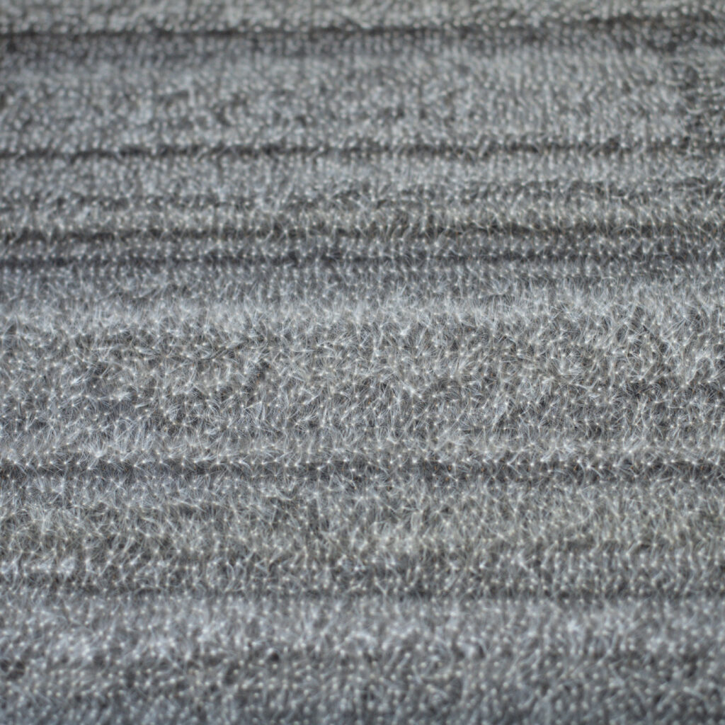 Nahaufnahme der Oberfläche einer Bildtafel mit dicht gesetzten Löwenzahnsamen in vertikaler Ausrichtung.