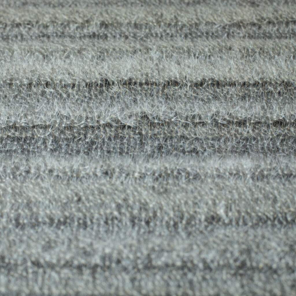 Nahaufnahme der Oberfläche einer Bildtafel mit dicht gesetzten Löwenzahnsamen in vertikaler Ausrichtung.